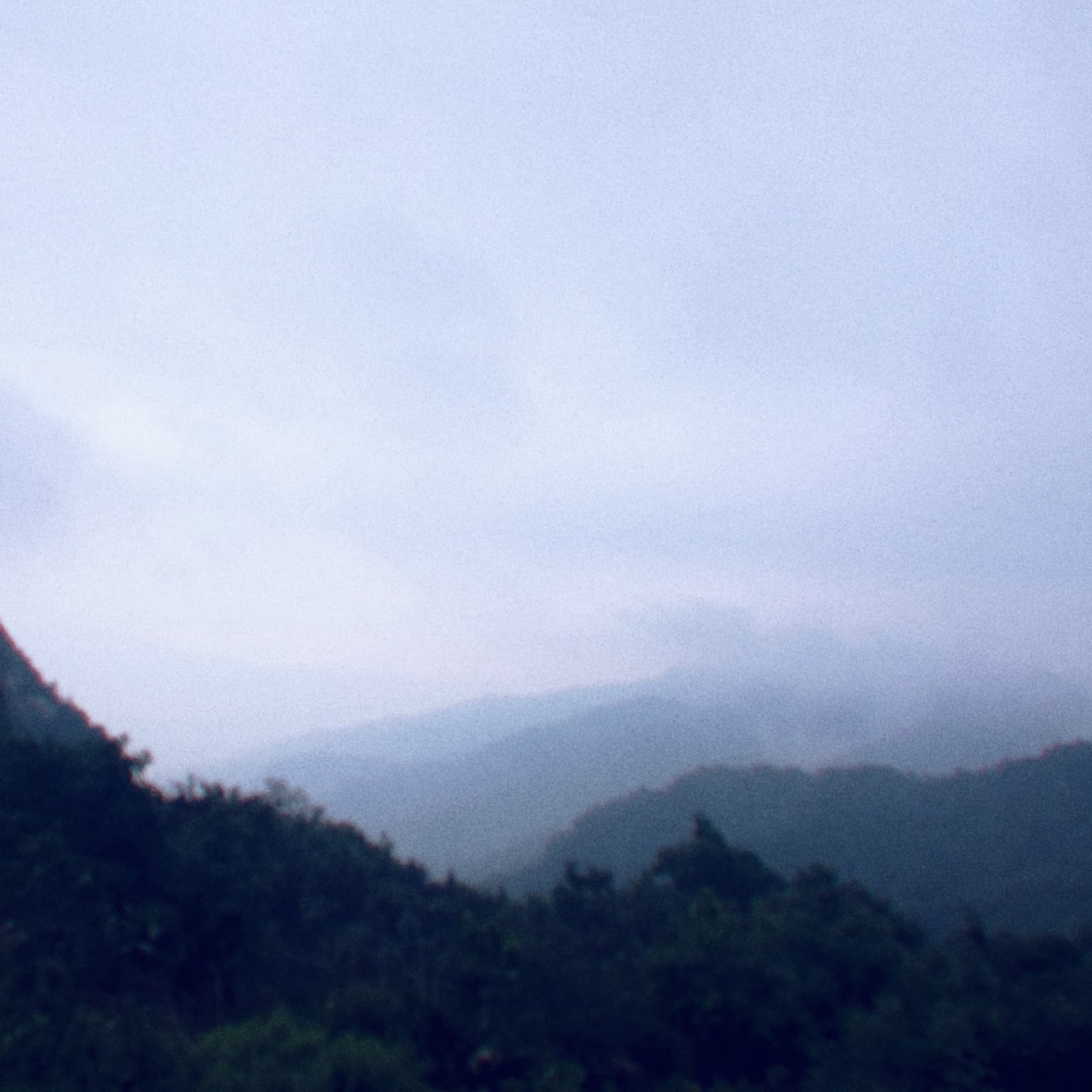 Mist settling over distant mountain ridges